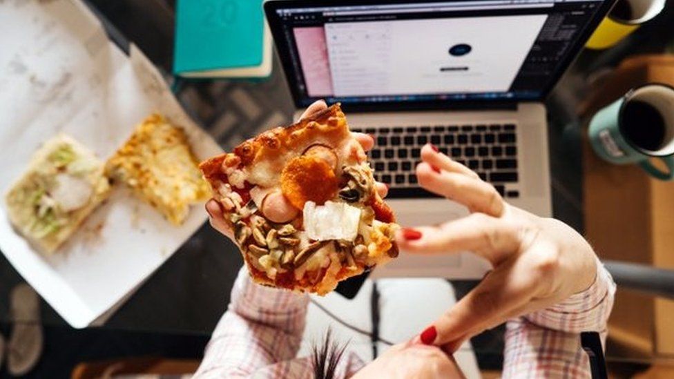Pizza being eaten in front of computer