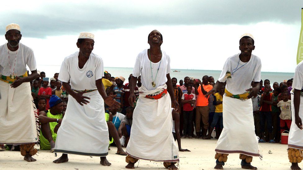 Alongside, men wearing white kikoi dance to entertain those who turned out at the finish line