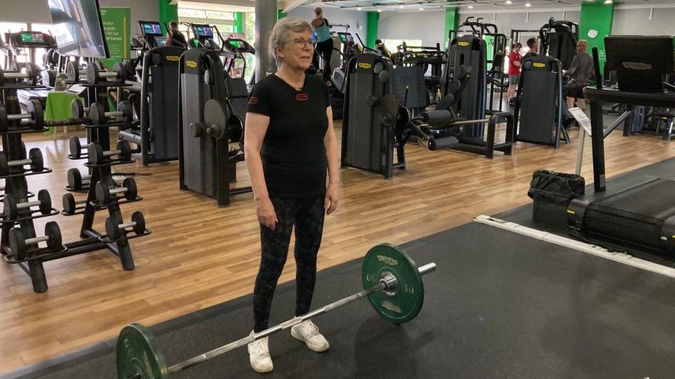 Peeps Nicol standing by a barbell in the gym