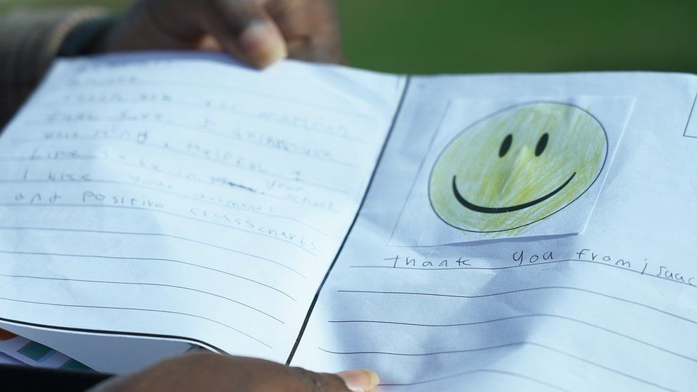 A thank you card written by Isaac Uzoegbu, with a big yellow smiley face and the words "thank you from Isaac"
