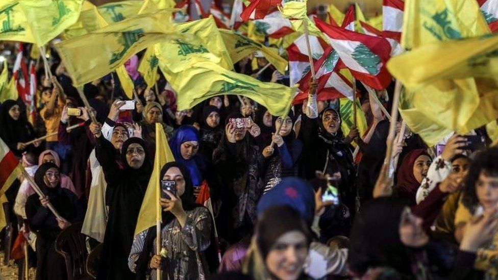 Hezbollah supporters wave Hezbollah flags as they listen to the speech of Hezbollah leader Hassan Nasrallah via a giant screen in southern suburb of Beirut, Lebanon, 14 August 2018