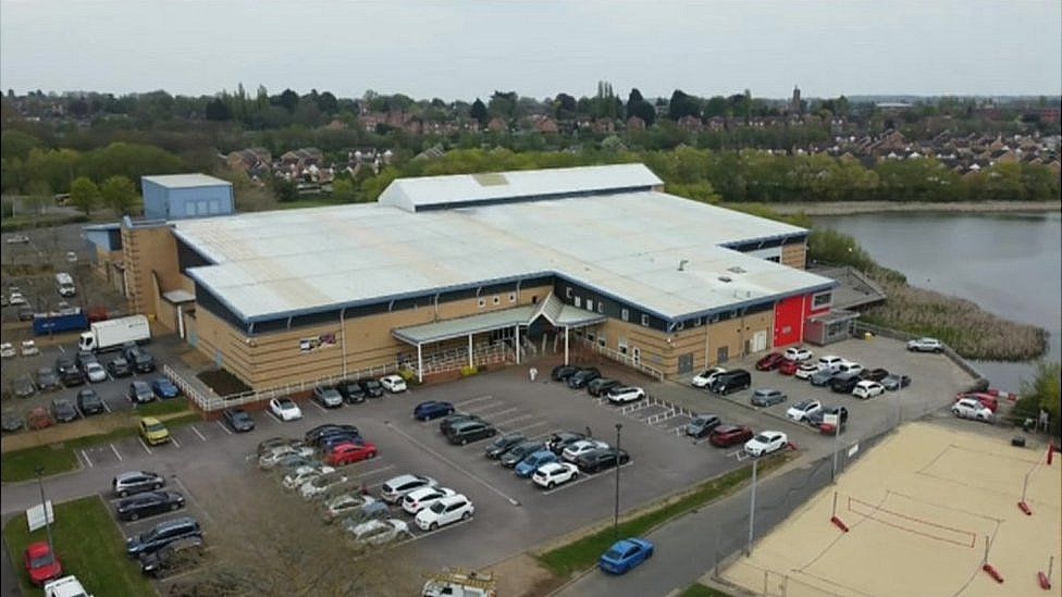 Kettering Leisure Village - two story brick and glass leisure centre with car park