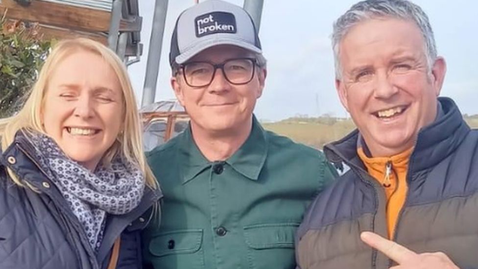 Michael Duignan and his wife posing for a photo with Rick Astley