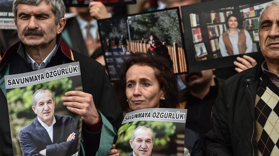 Protesters hold poster portraits of Cumhuriyet"s chairman Akin Atalayas they attend a demonstration at the courthouse in Istanbul on March 15, 2018.