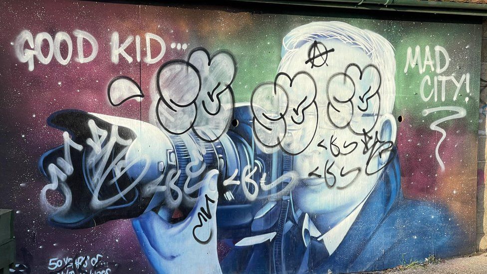 Shot of the vandalised mural with graffiti sprayed across