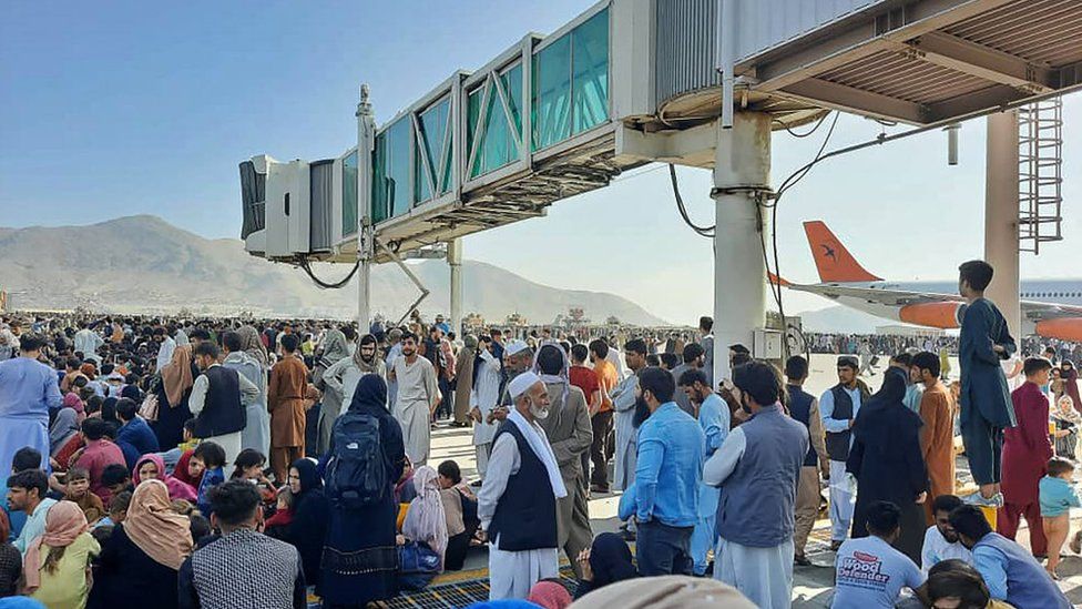 Afghans crowd at the tarmac of the Kabul airport