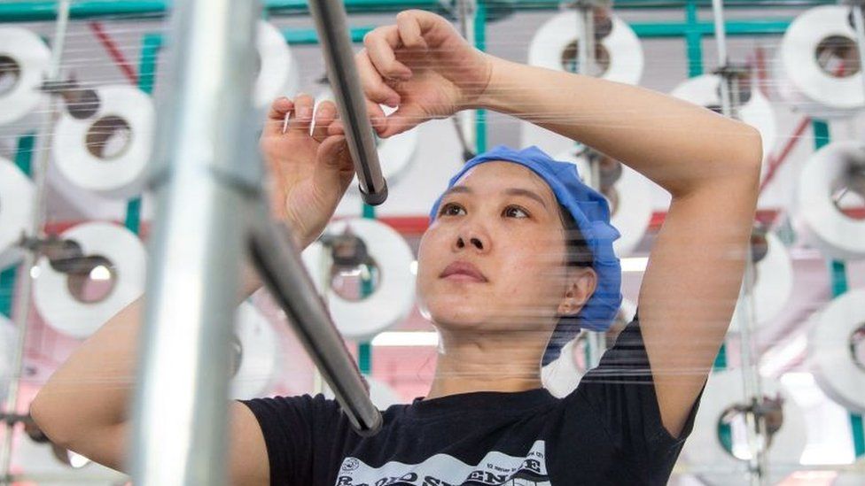 Рабочий на текстильной фабрике в городе Хайан, восточная провинция Цзянсу, Китай.