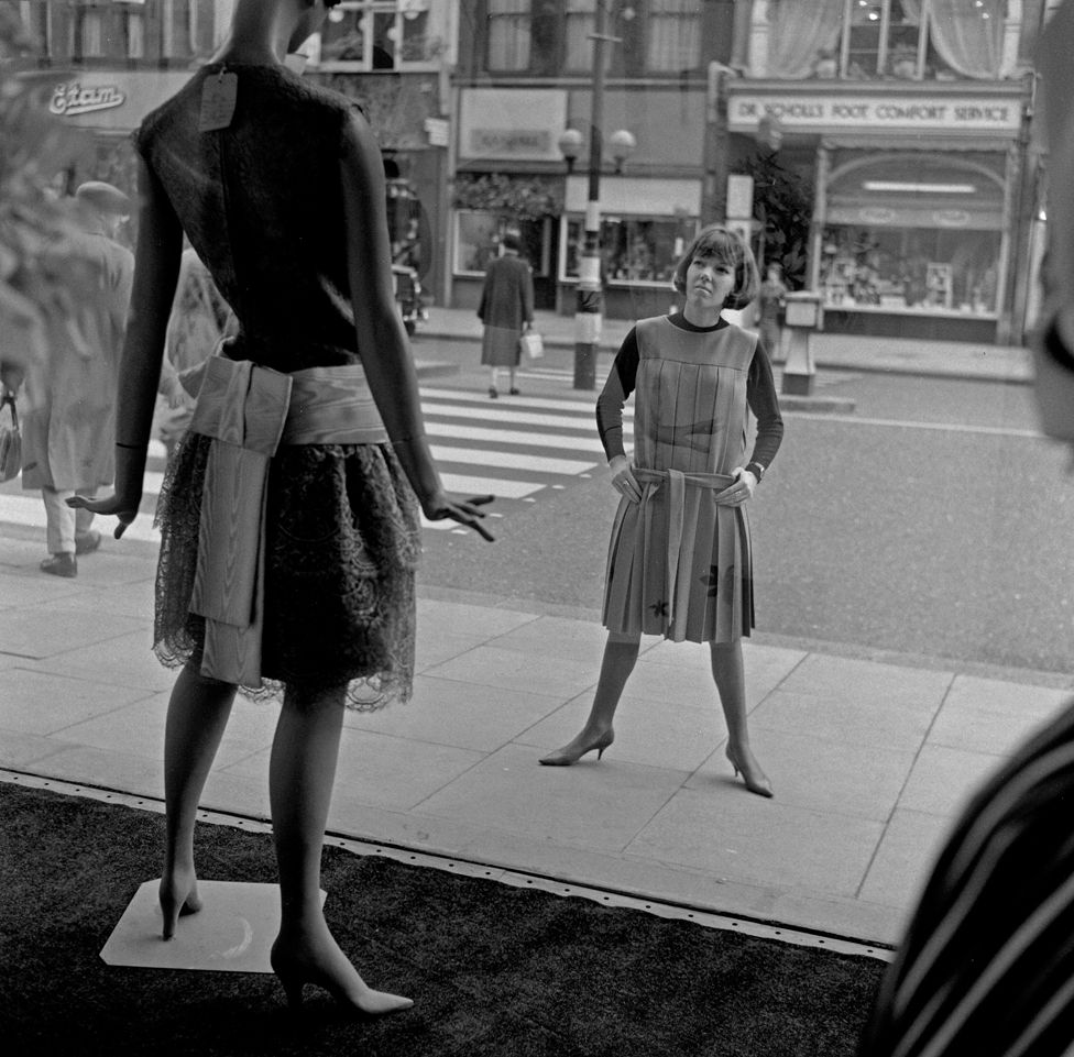 Мэри Куант, дизайнер одежды, стоит возле своего магазина Bazaar и смотрит в витрину, как сделал бы прохожий. Магазин Мэри находится на Бромптон-роуд, Найтсбридж, Лондон, SW1, 14 октября 1960 года.