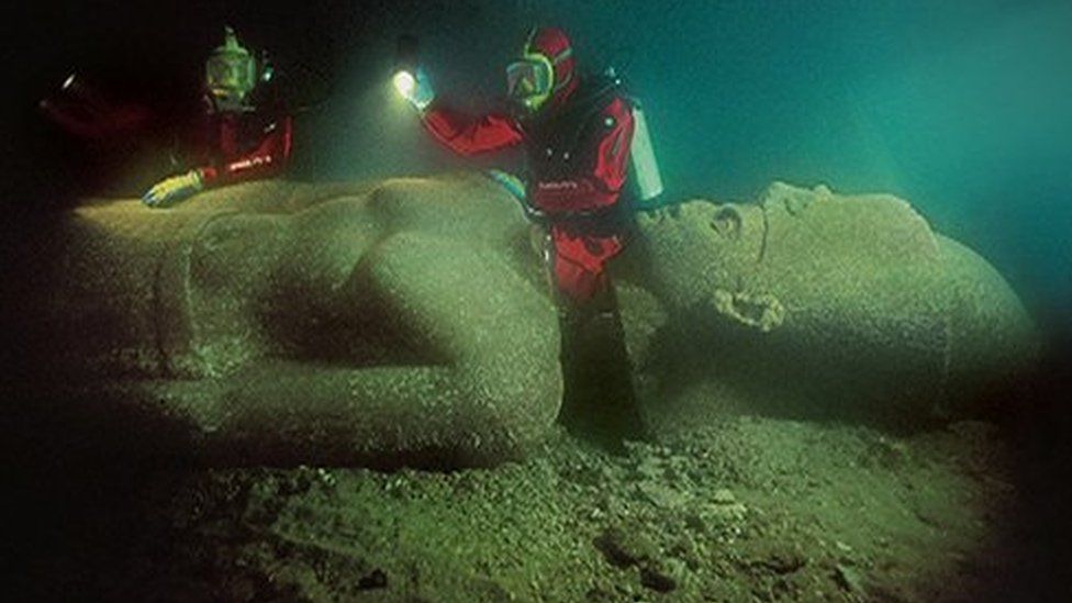 Divers and Egyptian statue