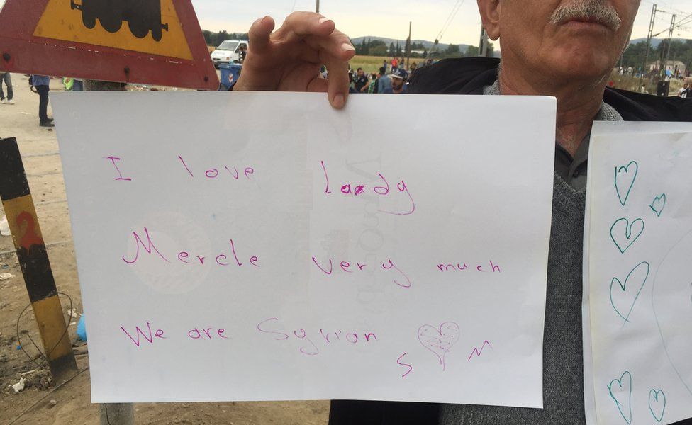 Syrian man holding paper sign saying "I love Lady Mercel"