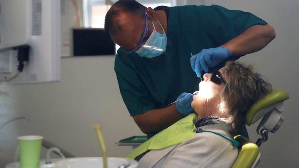 A dentist tends to a patient at Silveroaks Dental Surgery as it opens for non aerosol generating assessments in Milton Keynes