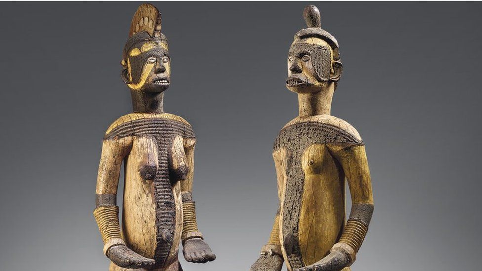 The wooden objects, one male and one female, represent deities from the Igbo community