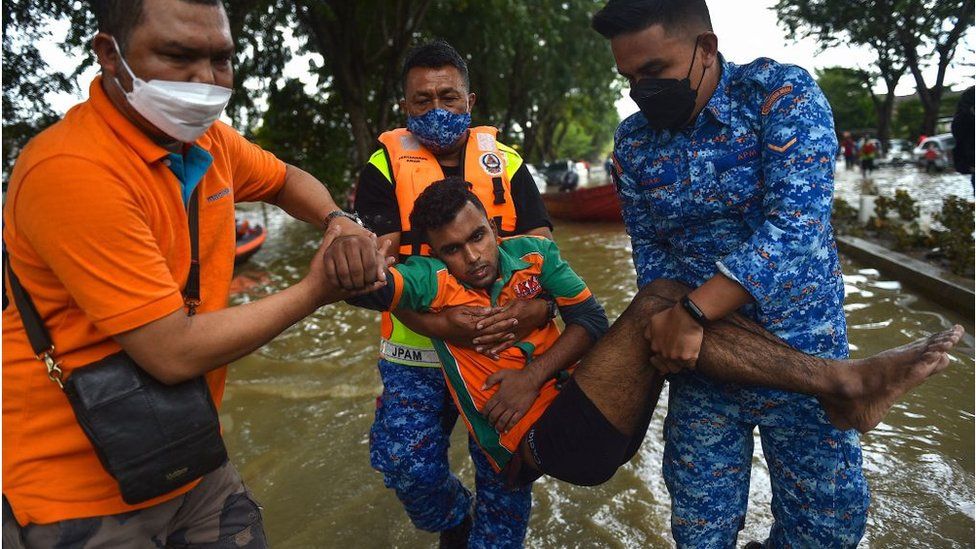 Members of the Malaysia Civil Defence Department carry a man, who had been trapped as a result of floods, in Shah Alam, Selangor on December 20, 2021.