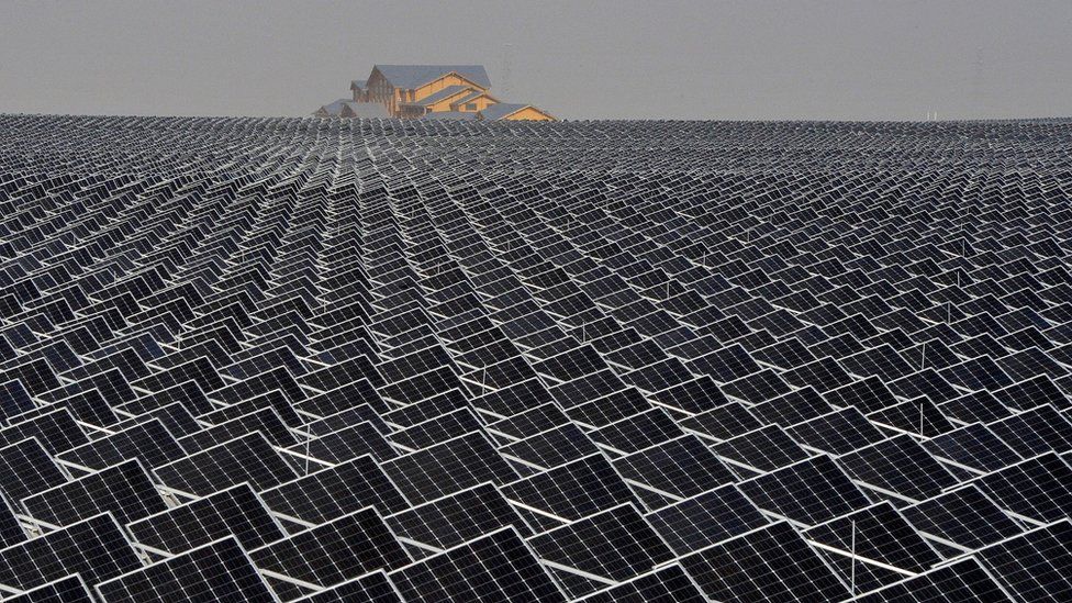 Solar panels are seen in Yinchuan, Ningxia Hui Autonomous Region, China. House in the distance