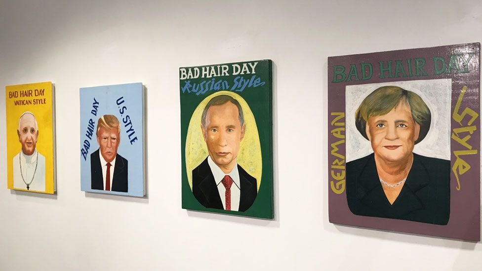 Four portraits of world leaders on the wall of art gallery