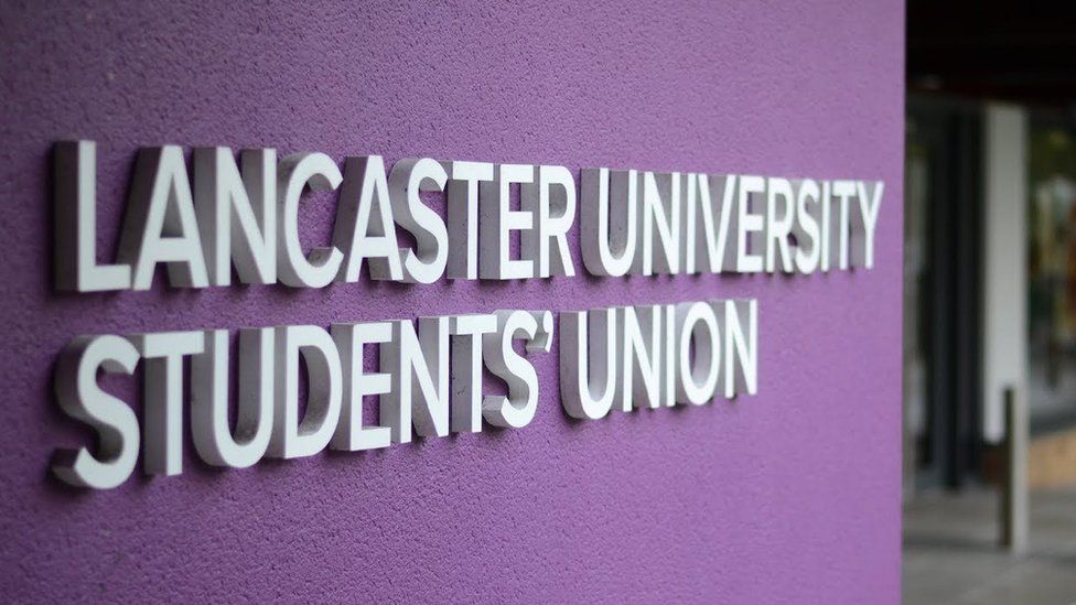 The Lancaster University Students' Union logo in white on a purple wall