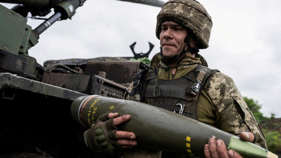 Ukrainian soldier carrying artillery shell