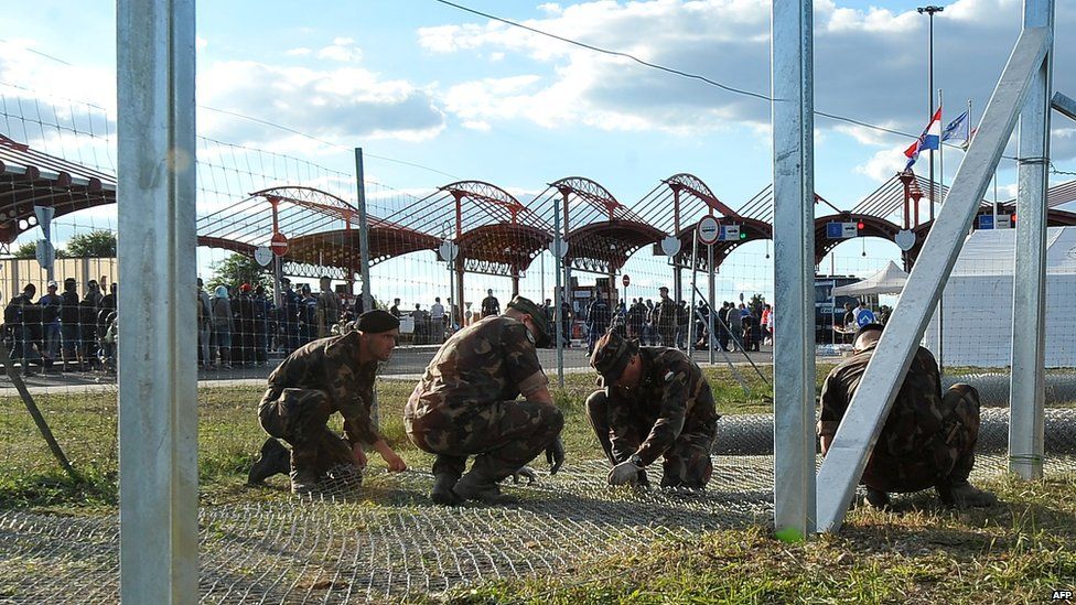 Hungarian soldiers raise a fence on the Croatian-Hungarian border
