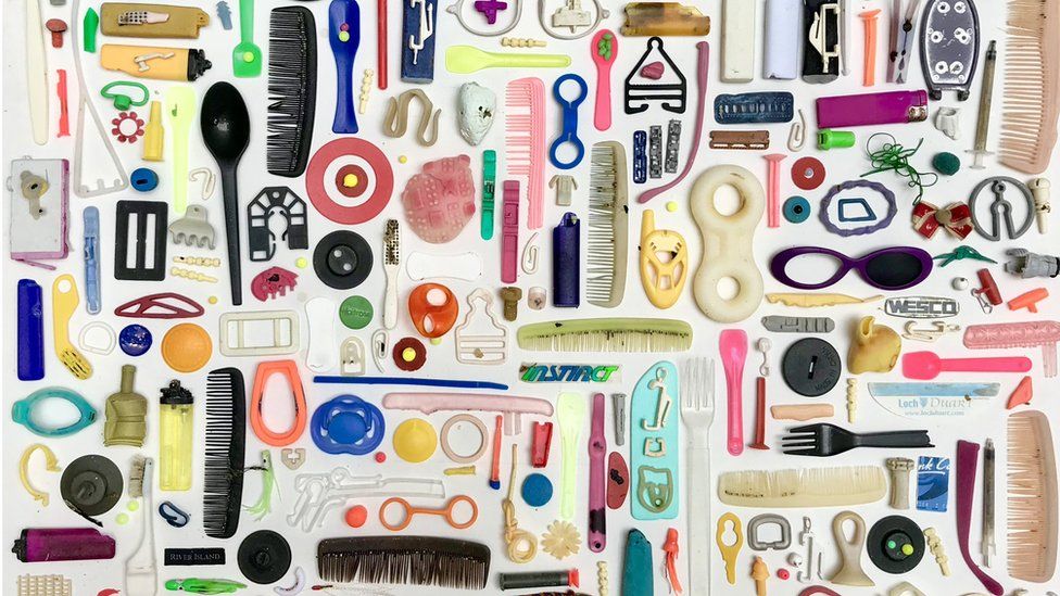 Colourful items of plastic waste assembled on white background