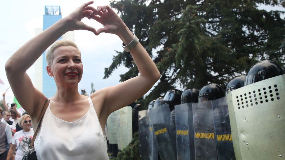Maria Kolesnikova making a heart sign with her hands in front of a group of riot police in Minsk
