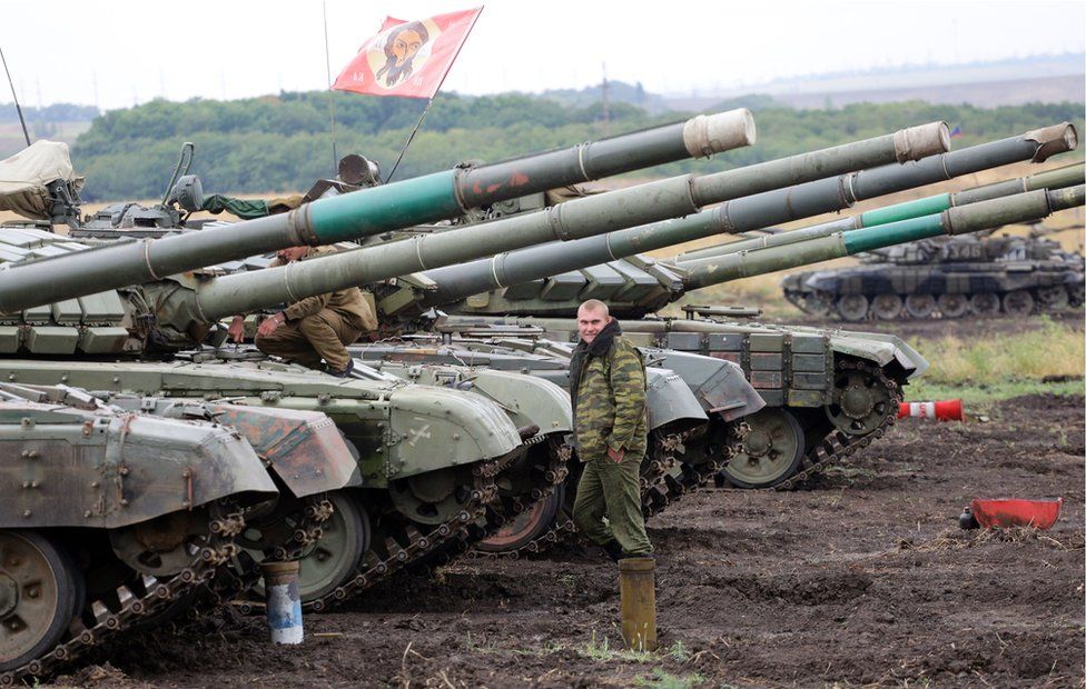 Pro-Russian separatists stand beside a tank in Donetsk