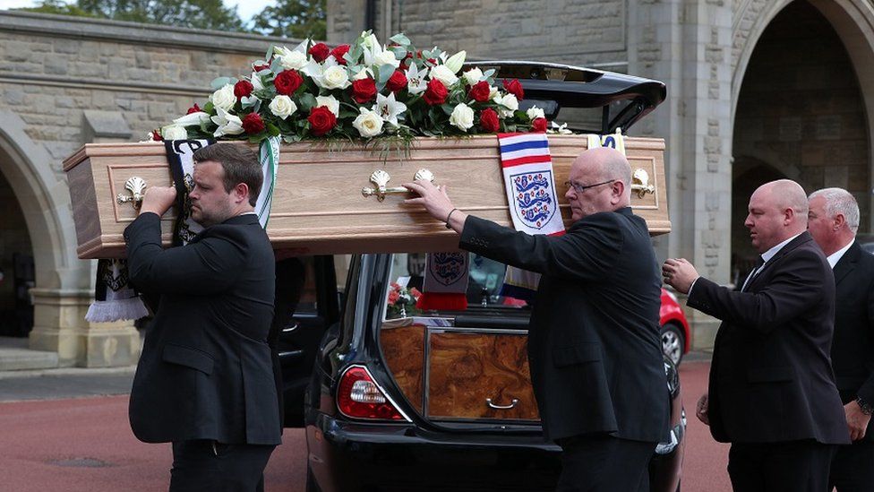 The coffin is carried into the service at West Road Crematorium