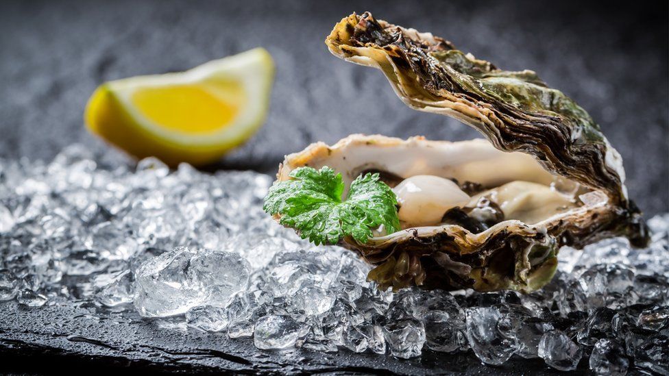 An oyster on ice with lemon