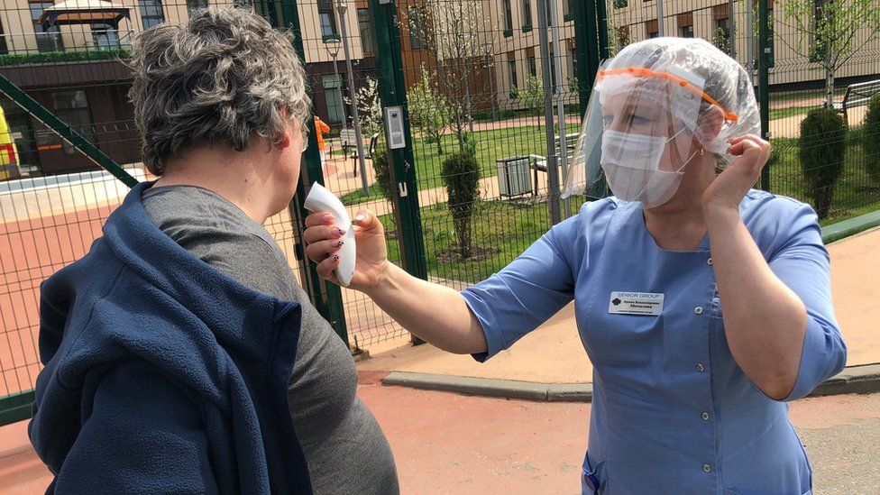 Man has his temperature taken outside care home in Moscow