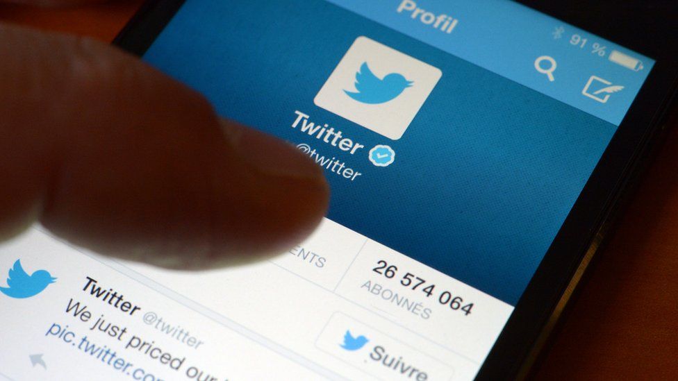 Thumb hovers over Twitter app on a smartphone