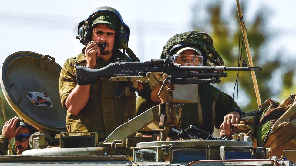 Israeli soldiers aboard an armoured personnel carrier (APC) on patrol near the border with the Gaza Strip, southern Israel.
