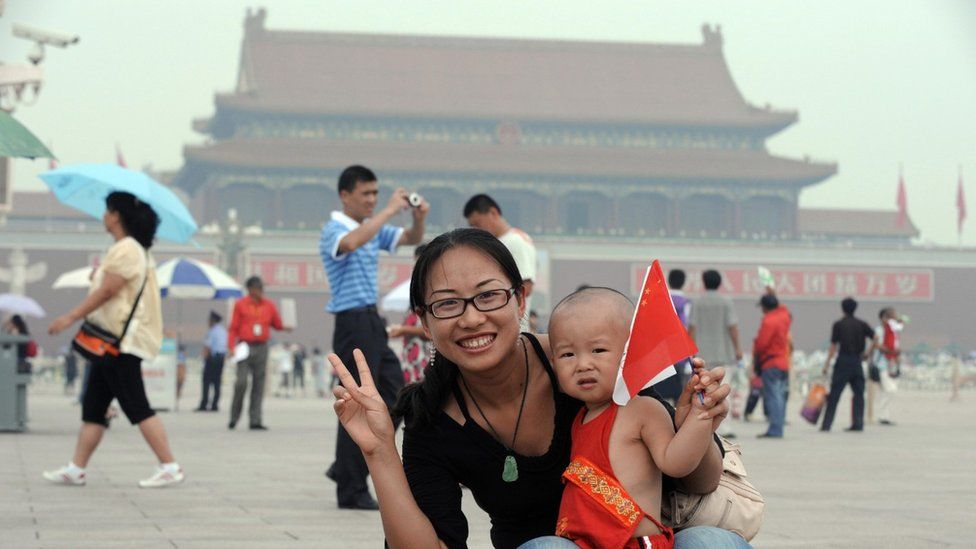 A mother poses with her baby in Tiananmen Square