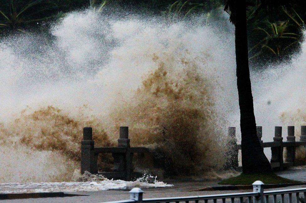 A wave caused by Typhoon Hato surges past the barrier along the seacoast in Zhuhai in China's southern Guangzhou province on 23 August 2017.