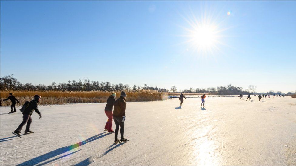 People ice skating on a frozen canal in the Weerribben-Wieden nature reserve in Overijssel during a cold winter day in The Netherlands on February 12, 2021 in Belt-Schutsloot, Netherlands.