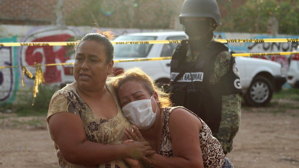 Women in tears outside a drug rehabilitation facility where assailants killed multiple people in Irapuato, Guanajuato, Mexico on 1 July 2020