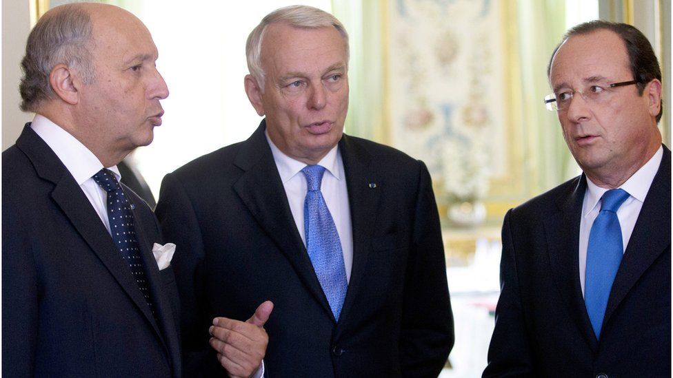 French President Francois Hollande, right, speaks to Laurent Fabius (left), and Jean-Marc Ayrault, in Paris (August 2013)