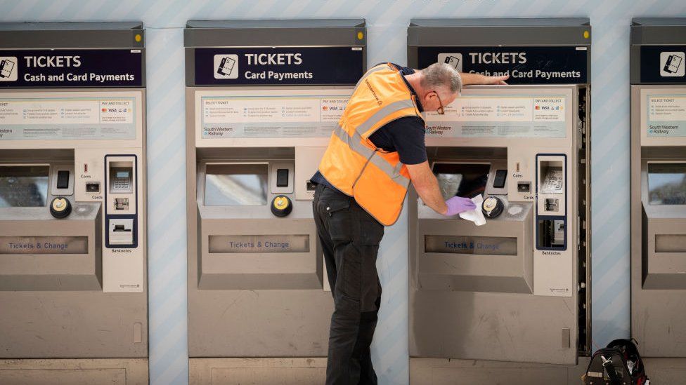 Station staff cleans a ticket machine on Waterloo station's main concourse