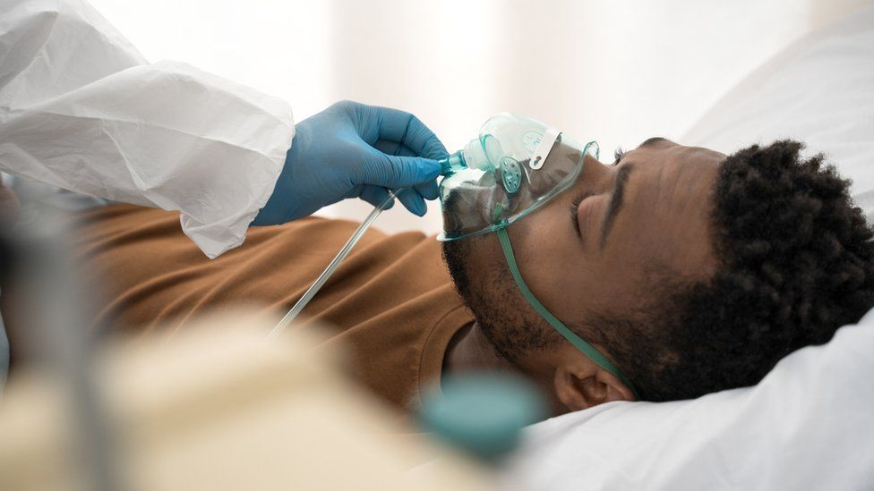 A man receives oxygen treatment through a ventilator
