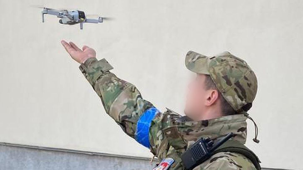 A Ukrainian soldier uses a small consumer drone