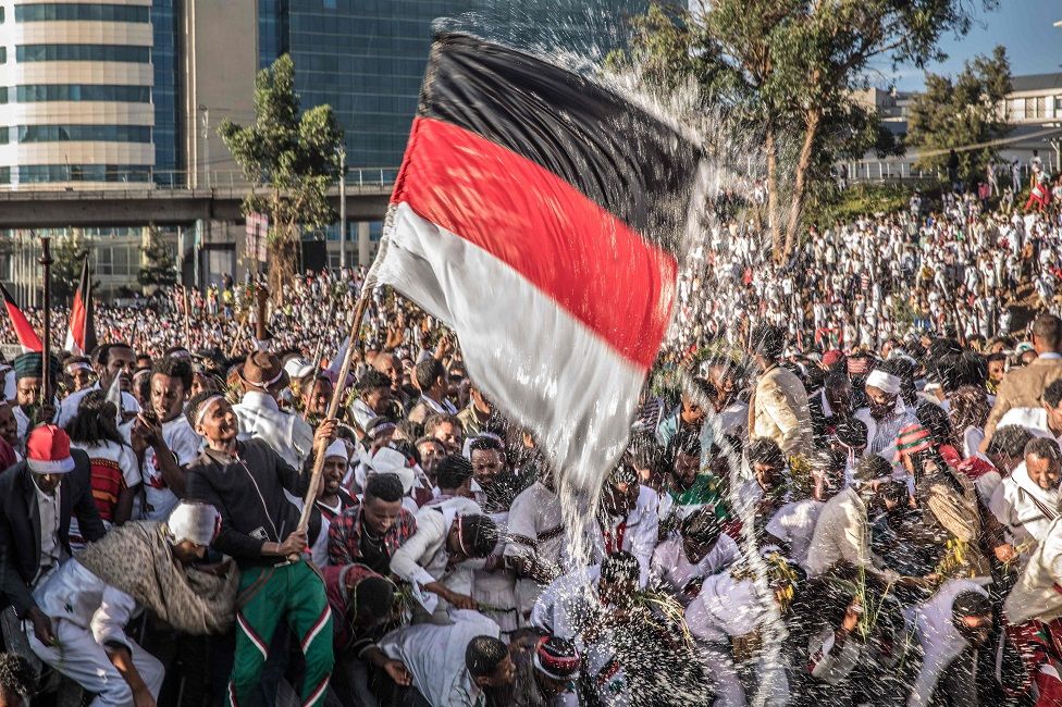 People waving a flag and spraying water