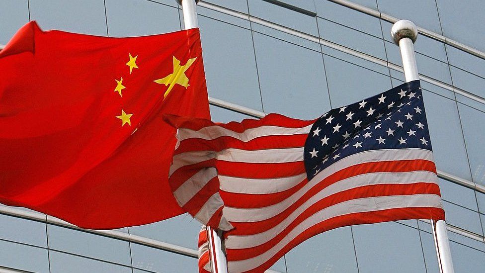 A US and a Chinese flag wave outside a commercial building in Beijing