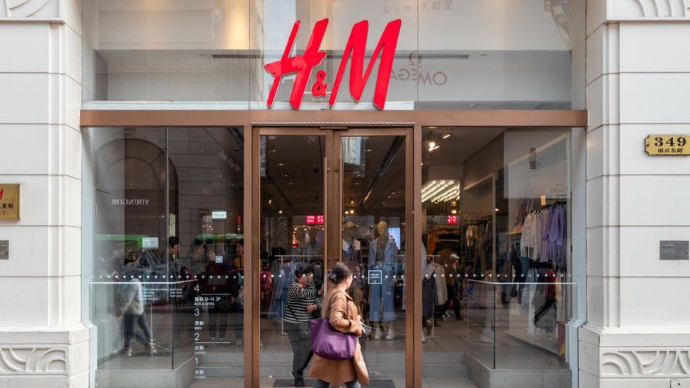 Woman walks by H&M store in Shanghai