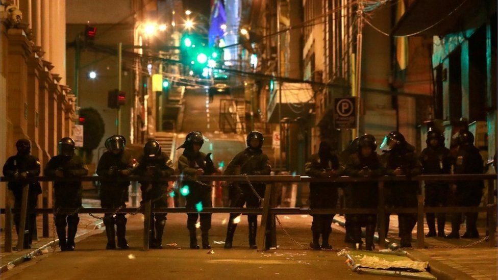 Riot police blocking off a street in La Paz