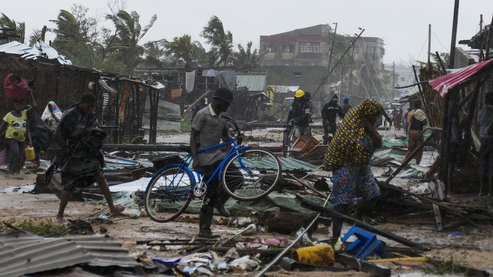 A man walks among the debris with his bicycle on a flooded street near Quelimane, as the storm Freddy hits Mozambique,