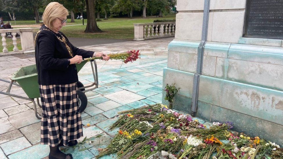 Mayor of Charnwood Jennifer Tillotson collects flowers from the Carillon Tower at Queen's Park, in Loughborough, Leicestershire