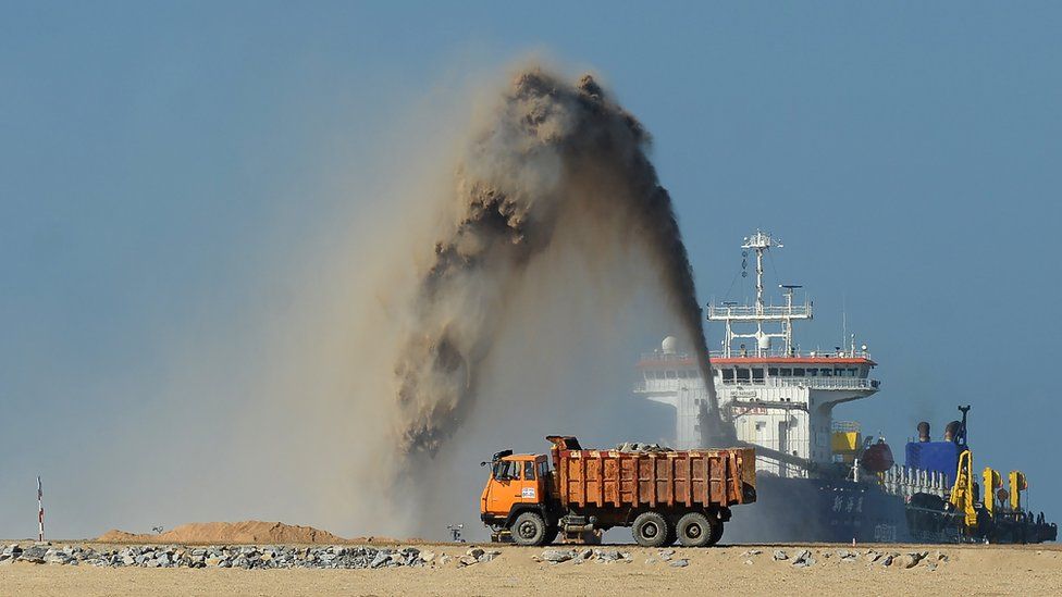 Pumps dredge sand to reclaim land at the site of a Chinese-funded 1.4 billion USD reclamation project in Colombo on December 5, 2017