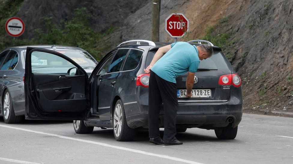 Removing a sticker connected  number-plates astatine  the Jarinje borderline  crossing betwixt  Serbia and Kosovo