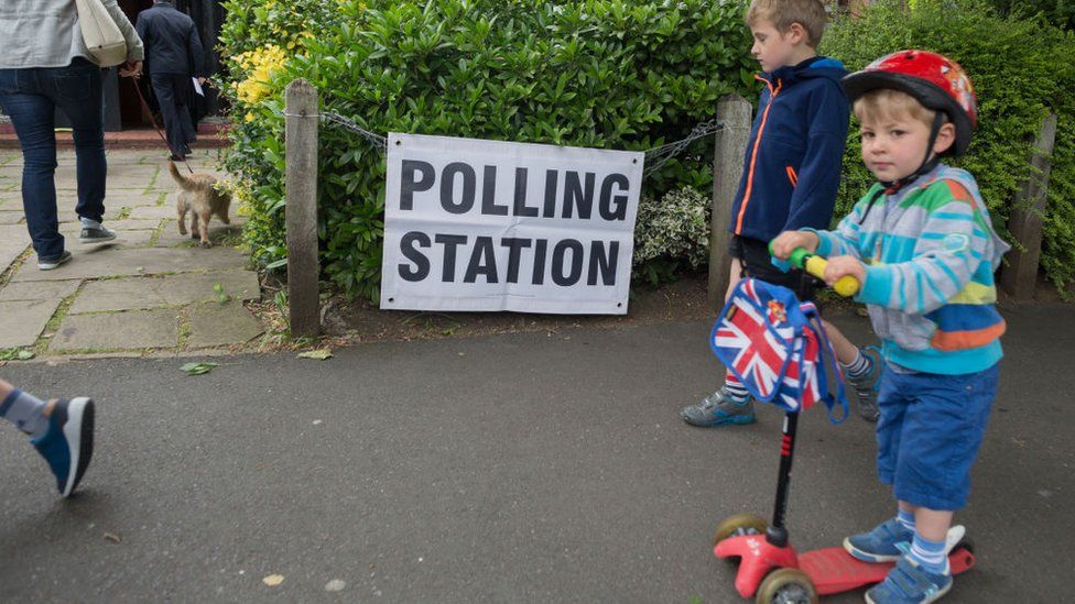 Child on a scooter outside polling station