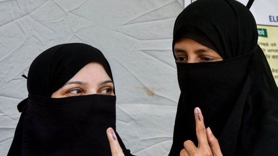 Muslims women show their ink stained finger after casting their votes at Dharavi on April 29, 2019 in Mumbai.