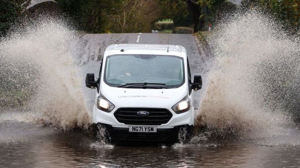 A white van drives through water after heavy rain in November 2023