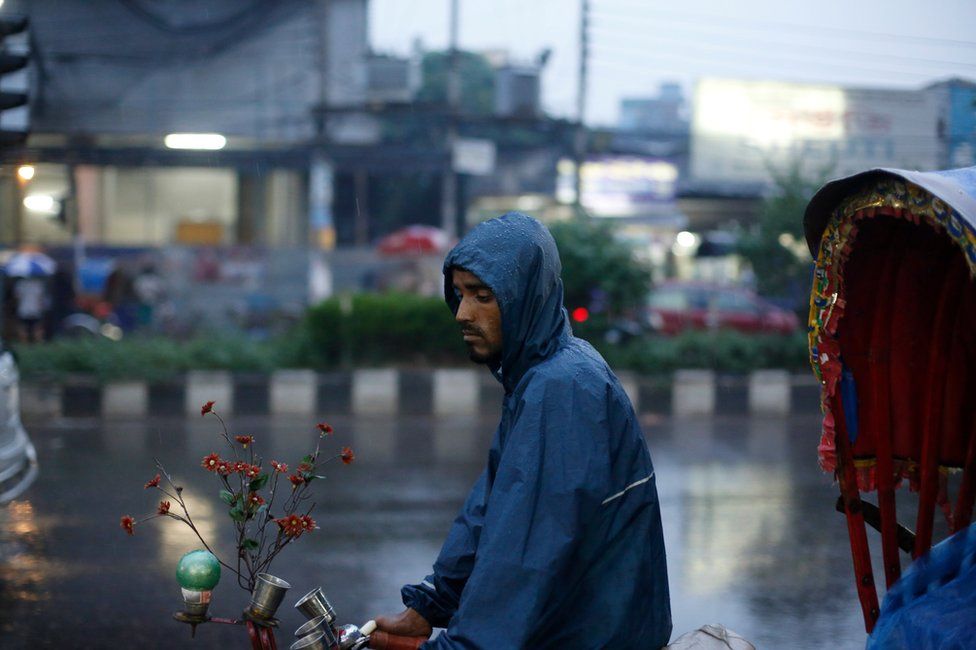 A rickshaw puller waits for passengers during rainy weather in the streets in Dhaka, Bangladesh, 29 May 2017.